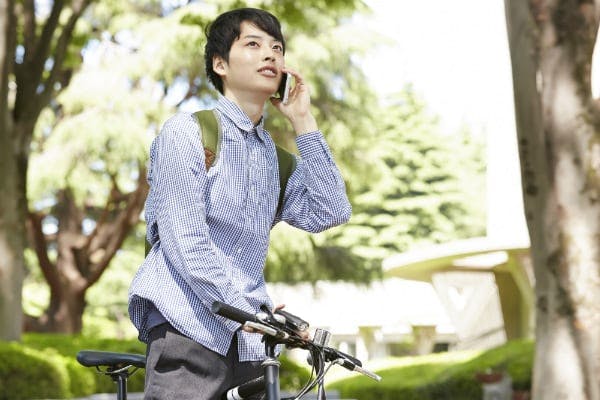 電話をしながら自転車に乗る男性